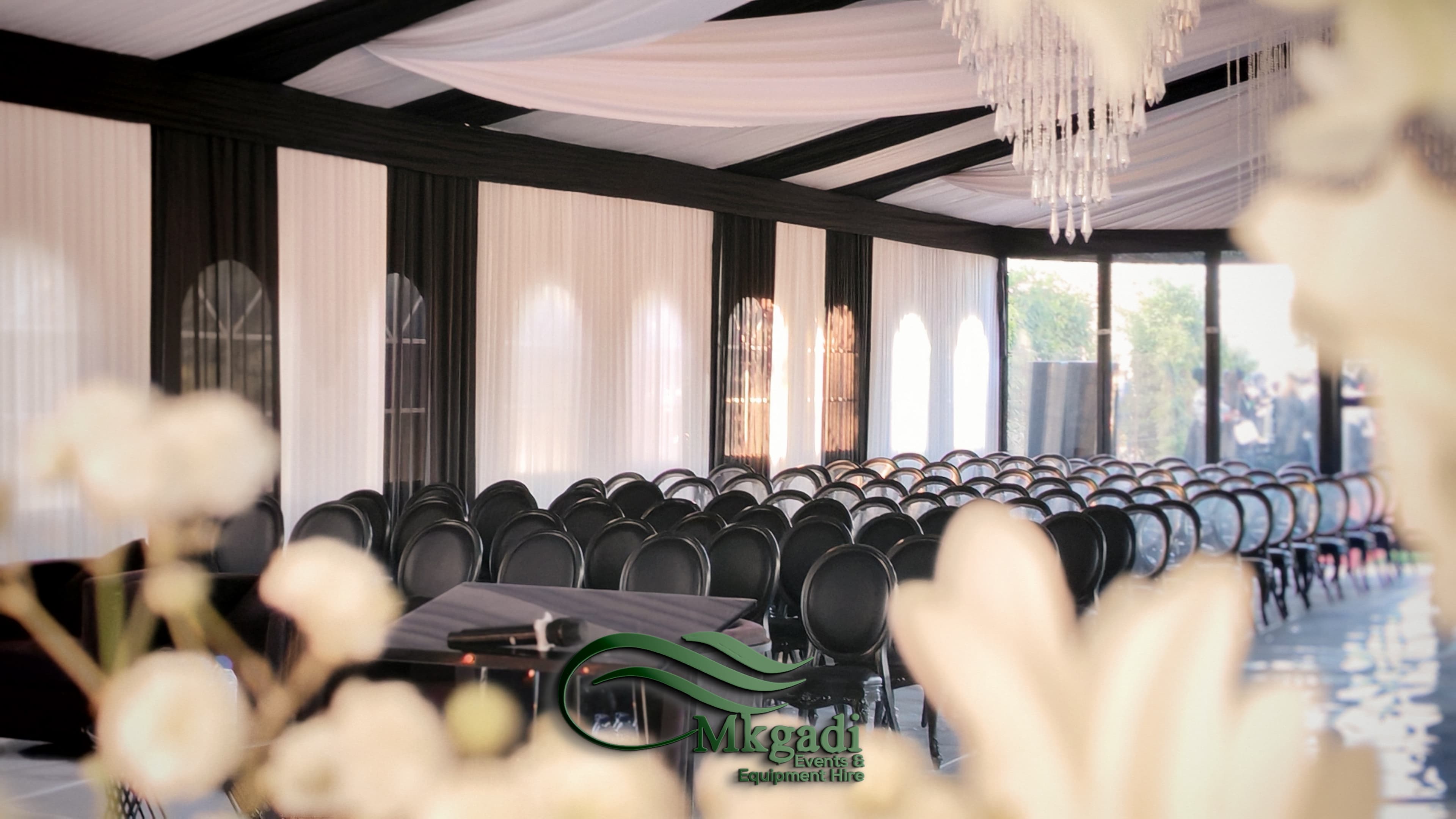 Elegant event space with draped fabric ceiling, floral centrepieces and soft ambient lighting creating a romantic atmosphere